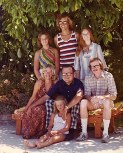 This was taken in 1974, when my parents were 40 and I was 5. We posed under the avocado tree that held my tree house, and you can see the pool reflected in the men's glasses. My siblings are Martha, David, Shannon, and Larry. I don't know why I had such a sour expression, but I bet it's because they made me sit on the ground since I was the littlest. 